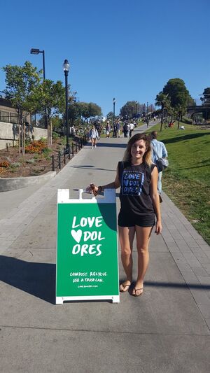 Volunteer with a Love Dolores sandwich board